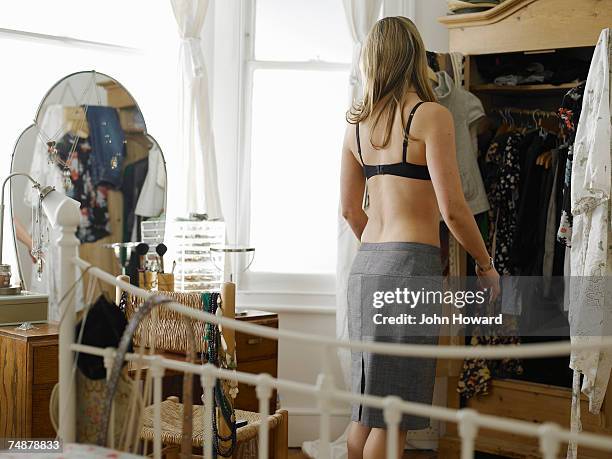 young woman dressing in bedroom, rear view - woman rear view mirror stock pictures, royalty-free photos & images