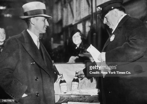 Arthur Ernstahl, the first person to bring liquor into the U.S legally after the repeal of The Eighteenth Amendment, declares two bottles of cognac...