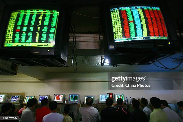 Investors view stock prices displayed on computers at a securities company June 25, 2007 in Chongqing Municipality, China. Chinese stocks fell 3.67...