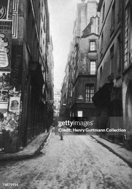 Girl walking up a narrow street in Paris at the crossroads of Bauborg and Brise Miche, circa 1900.