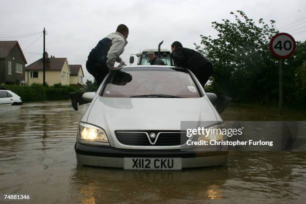 Stranded cars and residents battle the flood waters in the village of North Cave, near Hull in northern England on June 25 Hull, England. Much of...