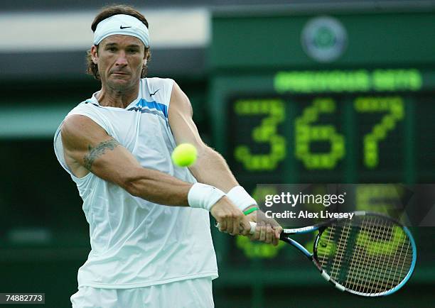 Carlos Moya of Spain hits a backhand during his Men's Singles first round match against Tim Henman of Great Britain during day one of the Wimbledon...