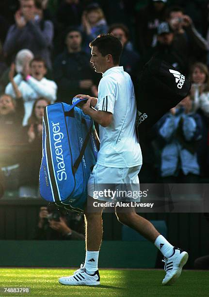 Tim Henman of Great Britain walks off of court as bad light ends play during his Men's Singles first round match against Carlos Moya of Spain during...