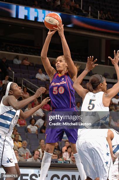 Tangela Smith of the Phoenix Mercury goes up for a shot over DeLisha Milton-Jones and Stacey Lovelace-Tolbert of the Washington Mystics on June 13,...