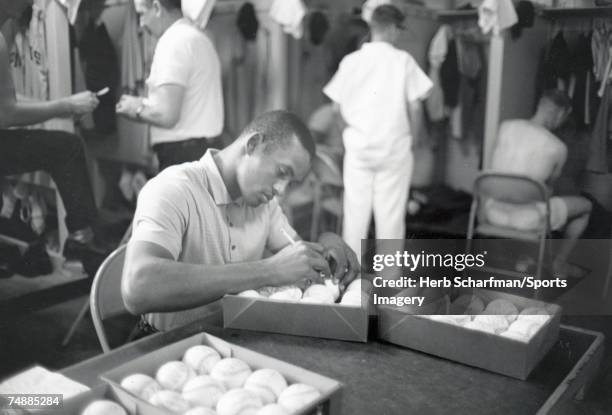 Roberto Clemente Pittsburgh Pirates signing baseballs before game against the Milwaukee Braves on September 24, 1960 in Milwaukee, Wisconsin.