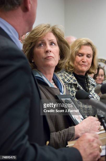 Mary Fetchet, of Voice of September 11th, holds a picture of her son, Brad, Sept. 11 victim, looks up at husband Frank as they appear with members of...
