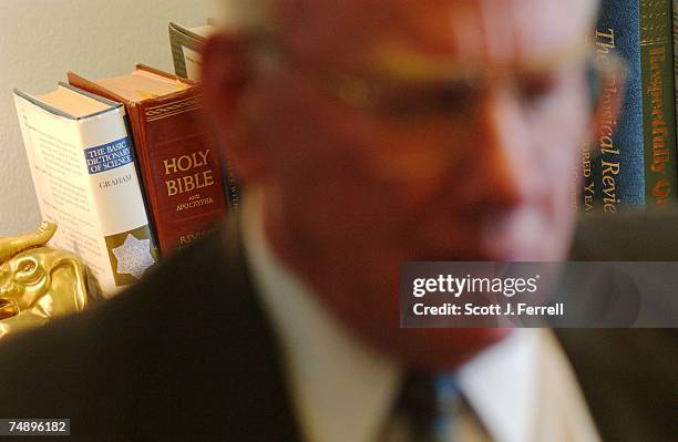 The Basic Dictionary of Science" and the "Holy Bible" sit side by side on a table behind Vernon J. Ehlers, R-Mich., during an interview in his...