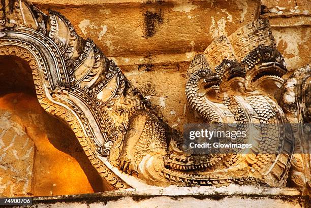 close-up of a multi-headed dragon carved on a stone wall, wat si sawai, sukhothai, thailand - dragon headed stock pictures, royalty-free photos & images