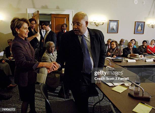 House Minority Leader Nancy Pelosi, D-Calif., shakes hands with forum moderator Joe Madison, a radio host on WOL/AM and XM Radio, as she arrives for...