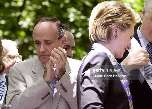 New York mayor Rudolph Giuliani looks down as U.S. Senate candidate and First Lady Hillary Rodham Clinton takes to the podium, during the Israel Day...