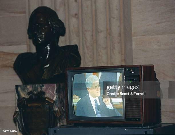 President Bill Clinton delivering his State of the Union address plays on a television set up for members' staff in the U.S. Capitol Rotunda. A bust...