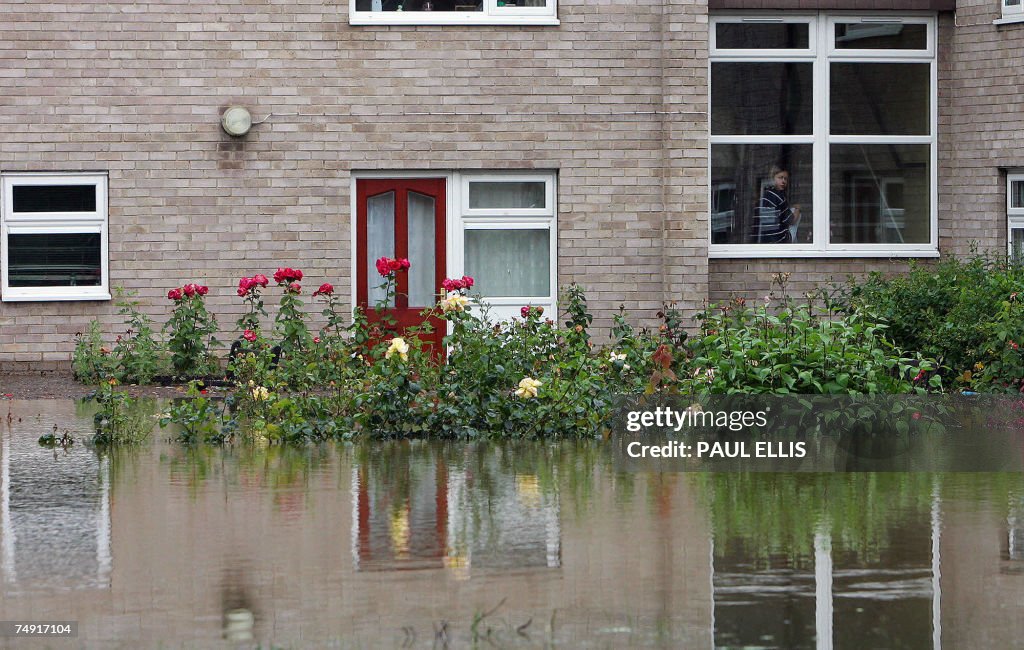 A woman looks out the window at her floo...