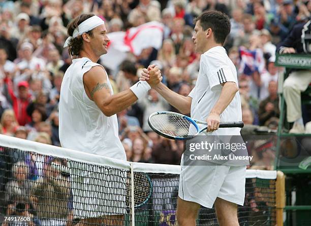 Victorious Tim Henman of Great Britain shakes hands with Carlos Moya of Spain following their Men's Singles first round match during day two of the...