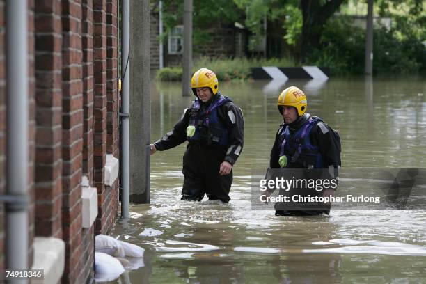 Firefighters search homes in the flooded village of Treeton which has rising floods due to the pumping of water from the Ulley Reservoir where the...