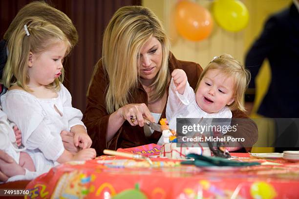 Dutch Princess Maxima cuts the cake for Princess Alexia celebrating her second birthday, while on her left sit Princess Catharina-Amalia and Crown...