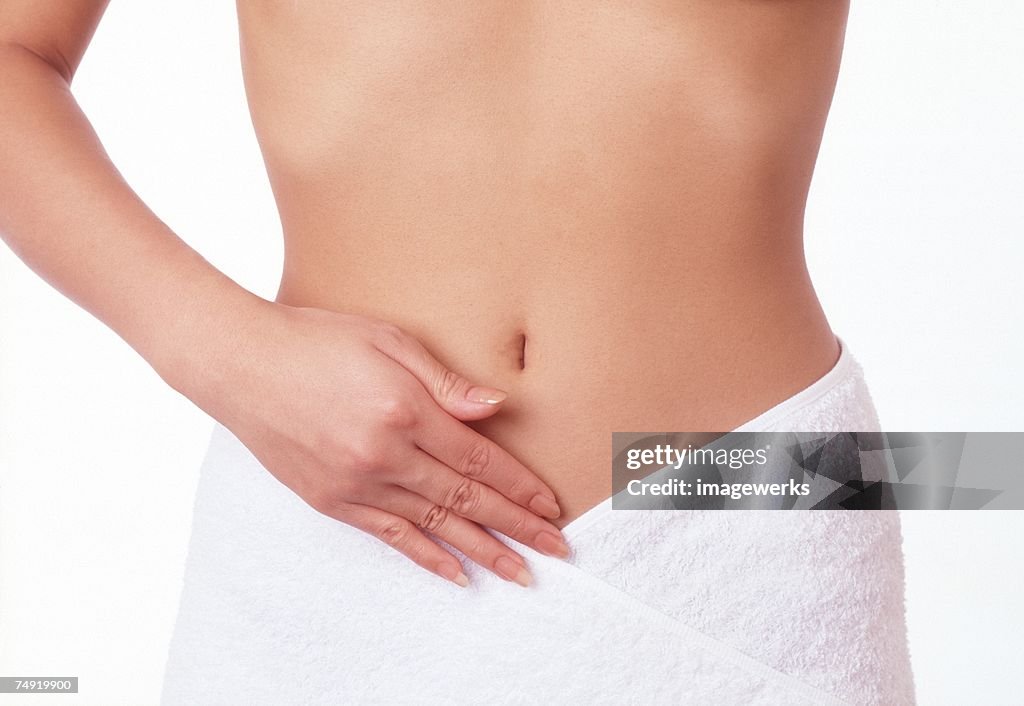 Midsection of a woman touching her stomach