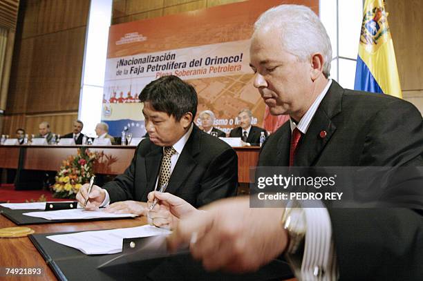 Venezuelan Minister of Energy & Petroleum Rafael Ramirez and the president of Chinese SINOPEC Zhu Acheng sign an agreement 26 June, 2007 in Caracas...