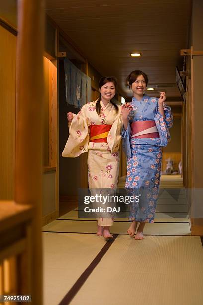 Portrait Of Two Women In Yukata Walking Hand In Hand Front View