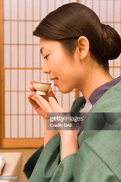 woman in yukata drinking sake, side view, japan - sake stock pictures, royalty-free photos & images