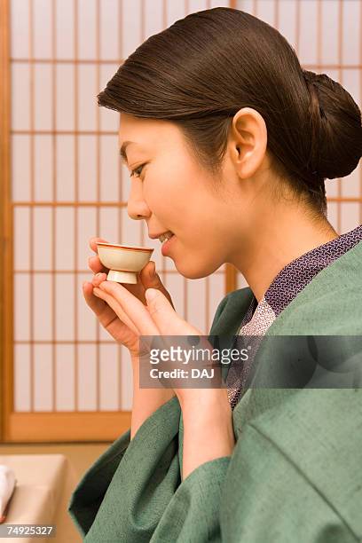 woman in yukata drinking sake, side view, japan - saké bildbanksfoton och bilder