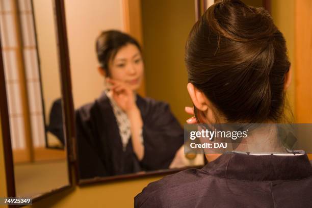 woman in yukata looking into the mirror, rear view, japan - rear view mirror stockfoto's en -beelden
