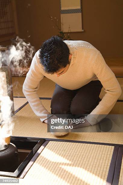 man attending japanese tea ceremony, bending over, front view, japan - bamboo dipper photos et images de collection