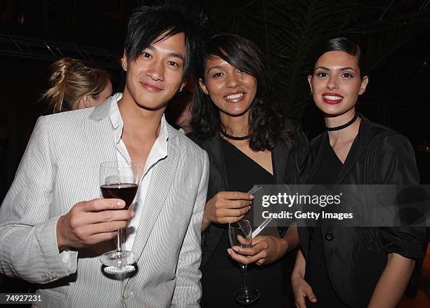 Singer Peter Ho of China poses with unidentified guests as he attends the Tag Heuer Grand Carrera event on June 26, 2007 in Le Castellet, France.