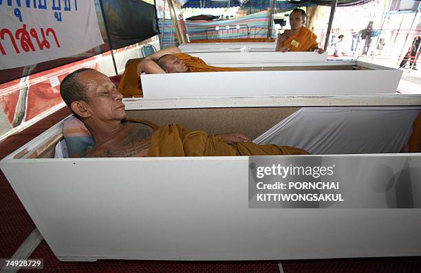 Thai buddhist monks lie inside coffins while on hunger strike during a protest in front of Parliament House in Bangkok, 27 June 2007. Buddhist monks...