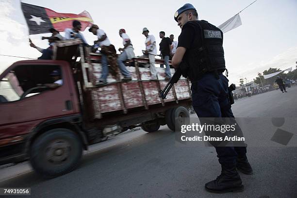 Peacekeeping Police Officer from Portugal stands guard as Fretilin supporters look on after a Fretilin campaign 3 days before election June 27, 2007...