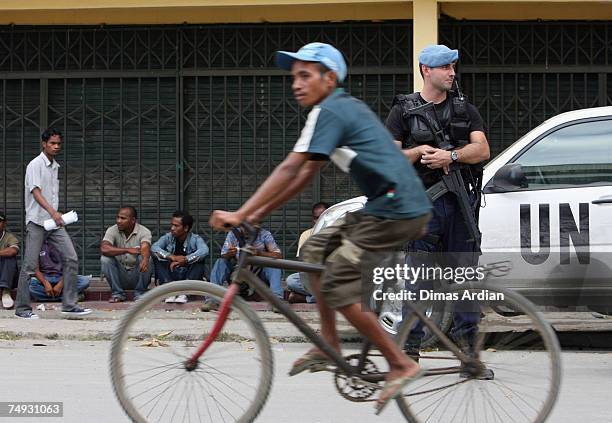 Peacekeeping Police Officer from Portugal stands guard as Fretilin supporters look on after a Fretilin campaign 3 days before election June 27, 2007...