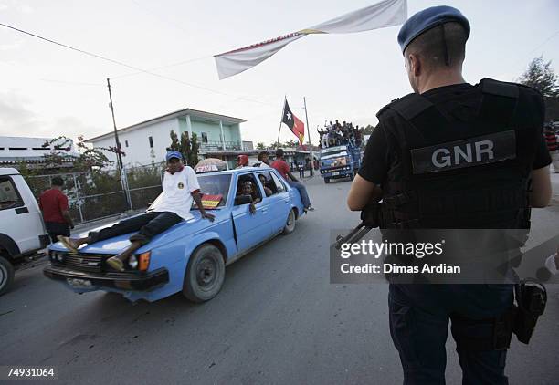 Peacekeeping Police Officer from Portugal stands guard as Fretilin supporters look on after a Fretilin campaign 3 days before election June 27, 2007...