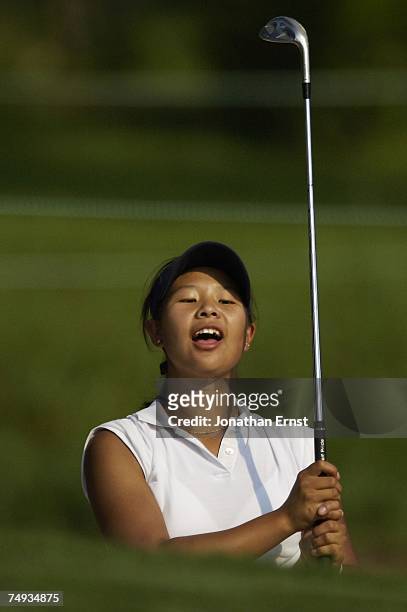 Joanne Lee watches her shot out of the sand to the third green in a practice round prior to the start of the U.S. Women's Open Championship at Pine...