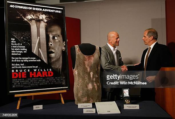 Actor Bruce Willis and Director of the National Museum of American History Brent Glass shake hands after Willis donated objects from the "Die Hard"...