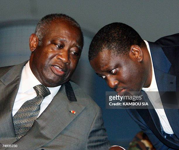Ivorian President Laurent Gbagbo speaks with Prime Minister Guillaume Soro during a meeting with Ivorian youth at the Culture palace 27 June 2007 in...