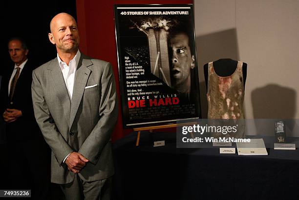 Actor Bruce Willis poses with objects from the "Die Hard" series of films that he donates to the Smithsonian's National Museum of American History...