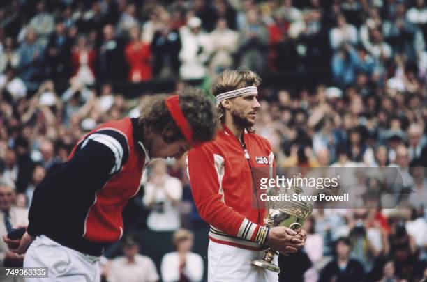 Bjorn Borg of Sweden holds the Gentleman's Singles trophy as John McEnroe looks down after losing their Men's Singles Final match at the Wimbledon...