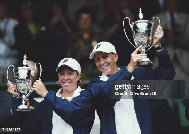 Lisa Raymond of the United States and Rennae Stubbs of Australia lift their trophy's after beating Kim Clijsters and Ai Sugiyama in the Women's...