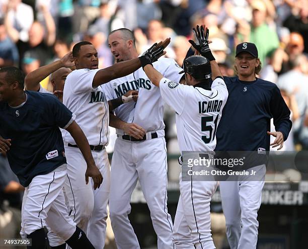 Ichiro Suzuki of the Seattle Mariners celebrates with teammates after he scored the winning run to defeat the Boston Red Sox 2-1 in the eleventh...