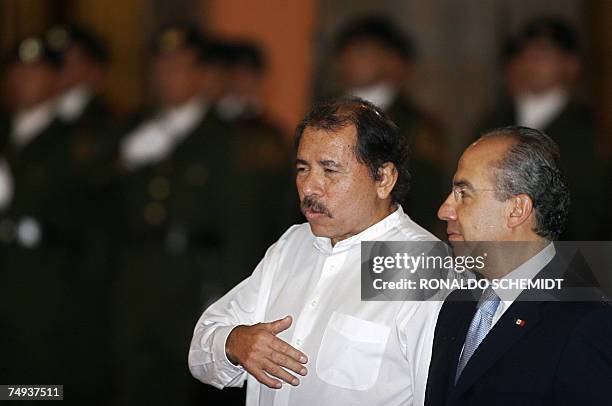 El presidente de Nicaragua Daniel Ortega habla con el presidente de Mexico Felipe Calderon durante los honores a la bandera en el Palacio Nacional,...