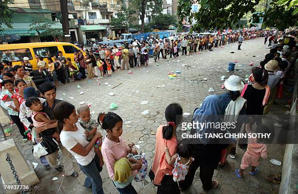 Cambodian mothers form a line as they carry their children in front of Kantha Bopha hospital in Phnom Penh, 19 June 2007. Saing Ratha lies...