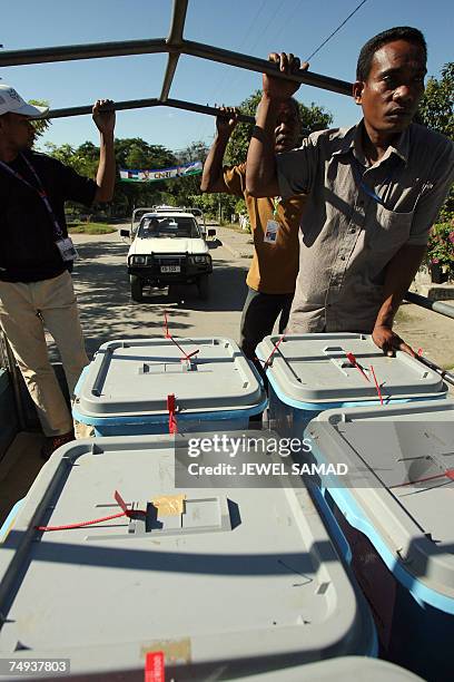 Electoral workers holds ballot boxes on the back of a truck as they transport ballot boxes in Dili, 28 June 2007, two days ahead of the parliament...