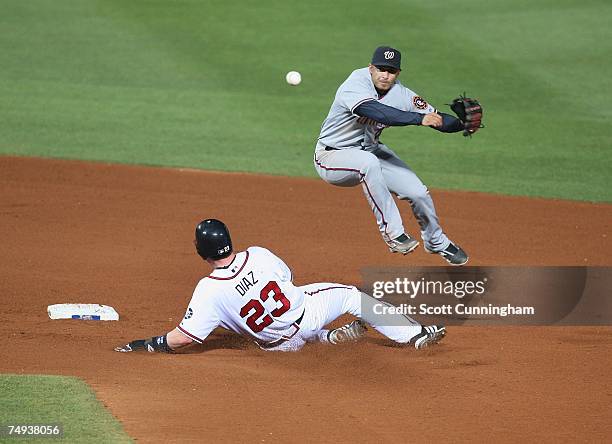 Felipe Lopez of the Washington Nationals turns a double play against Matt Diaz of the Atlanta Braves at Turner Field on June 27, 2007 in Atlanta,...