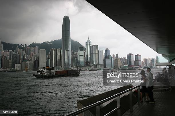 Toursits standing at the Kowloon Island, look at the Hong Kong Island located across the Victoria Harbor on June 27, 2007 in Hong Kong, China. The...