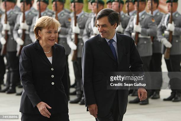 German Chancellor Angela Merkel and French Prime Minister Francois Fillon review a guard of honour upon Fillon's arrival at the Chancellery June 28,...