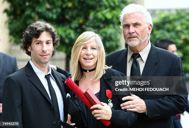 Singer Barbra Streisand poses with her husband James Brolin and her son Jason as she leaves the Elysee Palace after being awarded by French President...