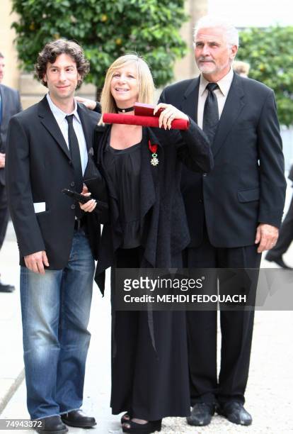 Singer Barbra Streisand poses with her husband James Brolin and her son Jason as she leaves the Elysee Palace after being awarded by French President...