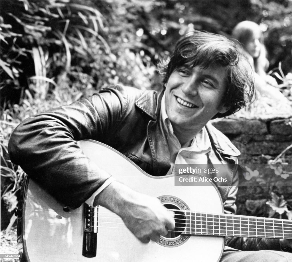 Folk singer Phil Ochs poses for a portrait with his acoustic guitar ...