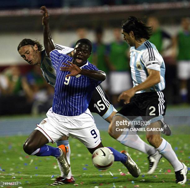 Forward Eddie Johnson of United States falls between Argentine Roberto Ayala and Gabriel Milito who makes a penalty during the group C football match...