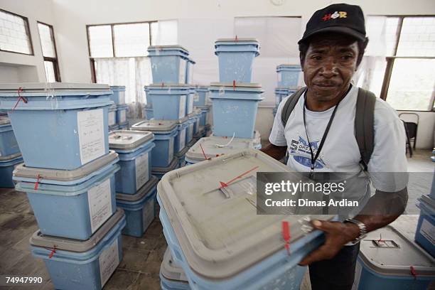 An election officer brings a ballot box to be distributed to districts amidst high tension one day before elections June 29, 2007 in Dili, East...