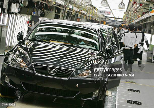 Workers at Japan's auto giant Toyota motor inspect newly assembled LEXUS cars at the company's Tahara plant in Aichi prefecture, 28 June 2007. 670...